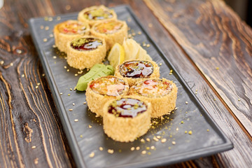 Set of unagi sushi rolls. Delicious sushi rolls with eel and avocado served with lemon, wasabi and ginger. Modern japanese food.