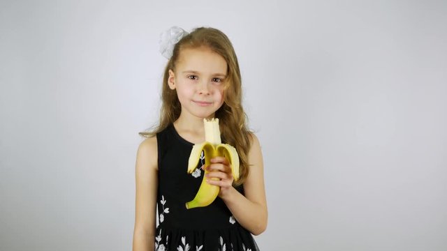 Beautiful girl eats banana cute smiling.
