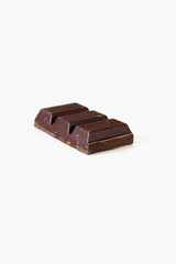 Piece of dark, bitter or semi-sweet couverture chocolate for baking or cake coating or glaze on...
