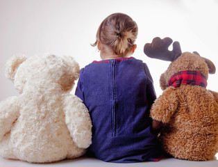 Cute little girl playing and reading book for teddy bear and elk. (happy childhood, education, knowledge concept)