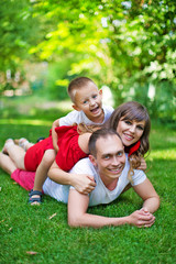 Fototapeta premium Happy family resting in the park on the lawn