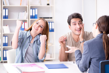 Young family agreeing mortgage contract in the bank for new hous