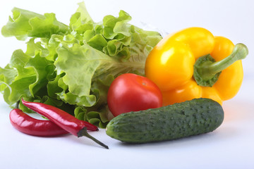 Assorted vegetables, fresh bell pepper, tomato, chilli pepper, cucumber and lettuce isolated on white background. Selective focus.
