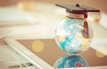 Graduate study abroad concept, Graduation cap on top Earth globe model map on laptop with Radar...