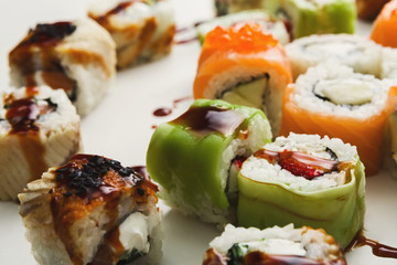Set of sushi rolls, maki with unagi sauce on white