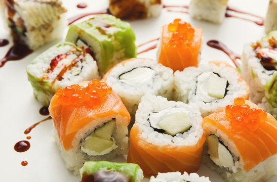 Set of sushi rolls, maki with unagi sauce on white