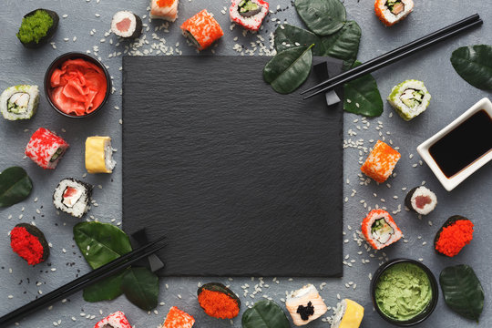 Square black slate with sushi on grey background