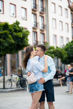 Young lovely couple hugging and kissing in city street