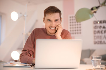 Young man working with laptop indoors