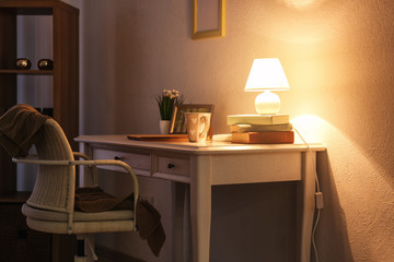Comfortable workplace with modern lamp on table