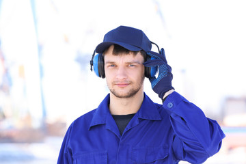 Male worker with headphones outdoors. Hearing protection equipment