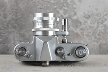 The old 35 mm SLR film camera on cement background.
