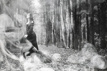Woman in a witch suit in a dense forest