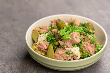 Tuna salad with cucumber and green peas in the bowl.