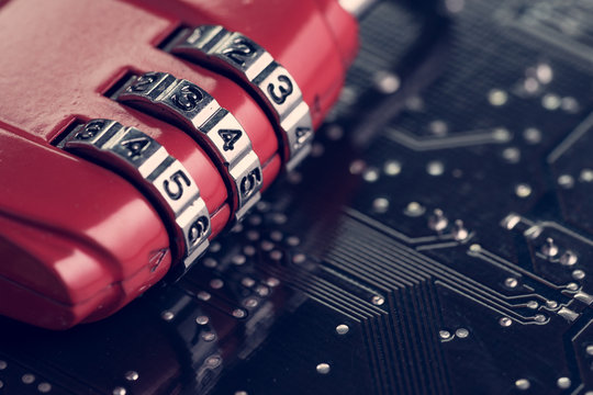 Code numbers on combination pad lock on computer circuit board with solder, digital cyber safety or security encryption concept, technology to encode online information or data protection