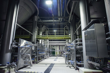 Stainless steel brewing equipment : large reservoirs or tanks and pipes in modern beer factory. Brewery production concept