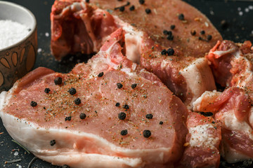 Raw meat, beef steaks on dark background, top view