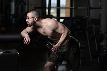 Fototapeta na wymiar Geek Man With Dumbbell Exercising Triceps