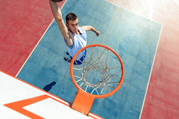 High angle view of basketball player dunking basketball in hoop
