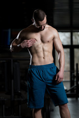 Obraz na płótnie Canvas Young Bodybuilder Flexing Muscles