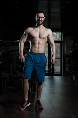 Fototapeta na wymiar Nerd Man Standing Strong In Gym