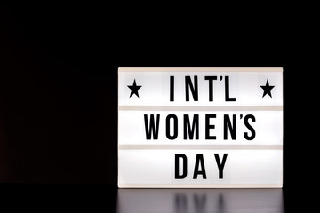 International Women's Day - concept - light box with cinema style lettering on black background with copy space