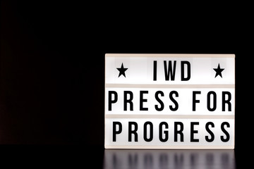 International Women's Day - concept - 'Press for Progress' 2018 theme  - light box with cinema style lettering on black background with copy space