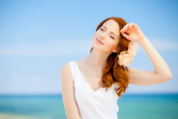 Fototapeta na wymiar redhead girl on the beach in summer