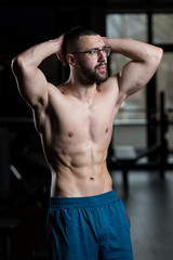 Fototapeta na wymiar Young Bodybuilder Flexing Muscles