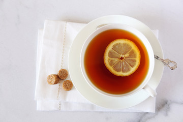 Black tea with lemon in a white bone china cup