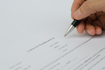 Hand signing a contract.