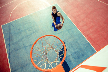 High angle view of basketball player dunking basketball in hoop