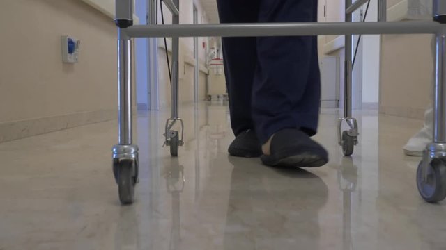 paziente cammina nel reparto di un ospedale con un girello