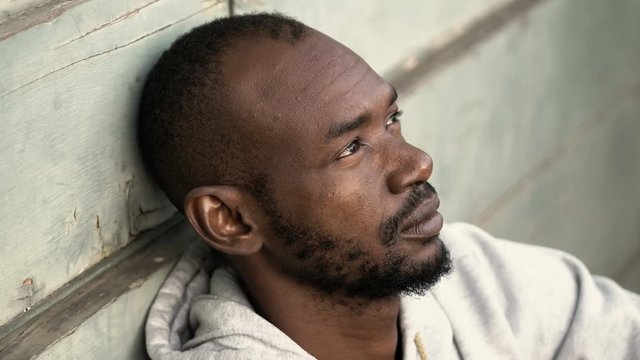 Close up portrait of sad and pensive african migrant - outdoor