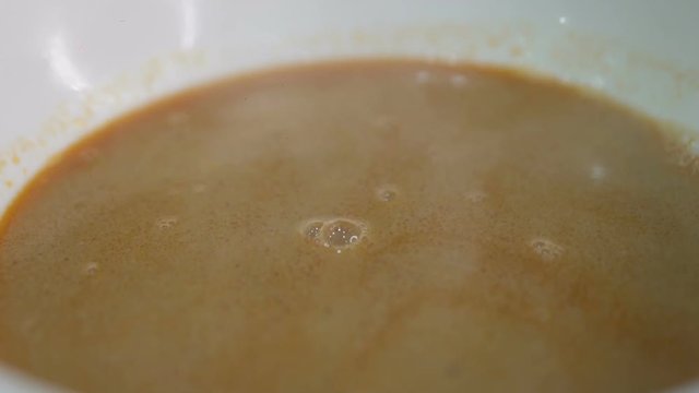 Closeup hot steaming schrimp soup in the porcelain bowl