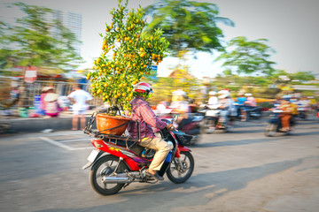 Ho Chi Minh City, Vietnam - February 13, 2018: A Vietnamese man is driving his motorcycle loaded...