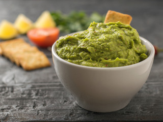 Freshly made guacamole. Eating avocado on a rustic table. Vegetarian cuisine.