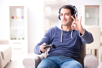 Young man playing computer games at home