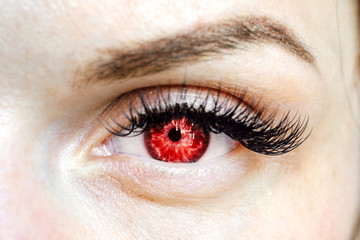 Obraz premium female red eye looking at the camera, color contact lenses
