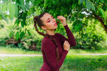Fototapeta premium Beautiful young woman with long braid and natural cherry earrings.
