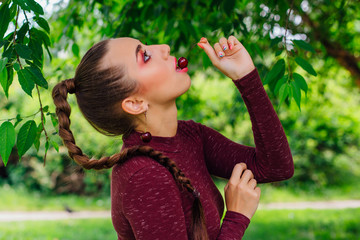 Beautiful young woman with long braid and natural cherry earrings.