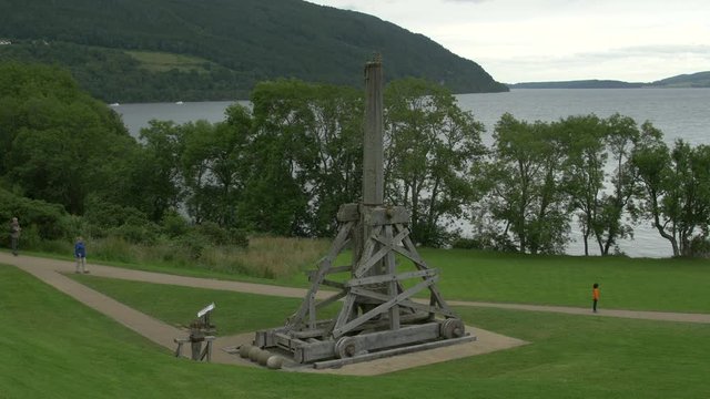 A wooden catapult near a lake