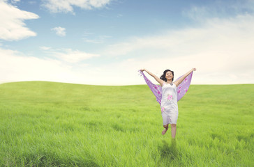 Naklejka na ściany i meble Beautiful asian woman running on green field