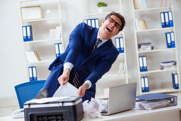 Businessman angry at copying machine jamming papers