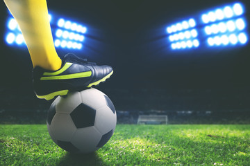 Closeup of foot holding on a soccer ball on field