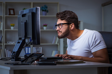 Young man staying late in office to do overtime work