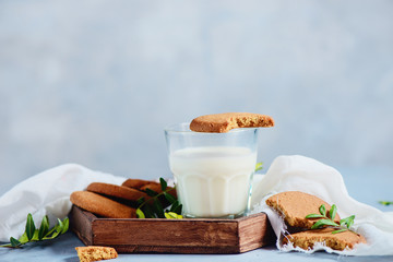 Breakfast with oatmeal cookies and milk in a wooden tray with white linen napkin. Natural minimalist concept with copy space.