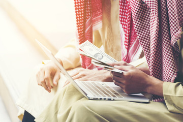 Handsome greedy arab man showing money on hands and counting money. Financial corruption Concept.