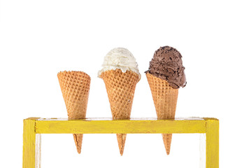 ice cream in waffle cones in rustic wood holder isolated on white background