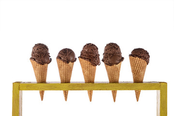 ice cream in waffle cones in rustic wood holder isolated on white background